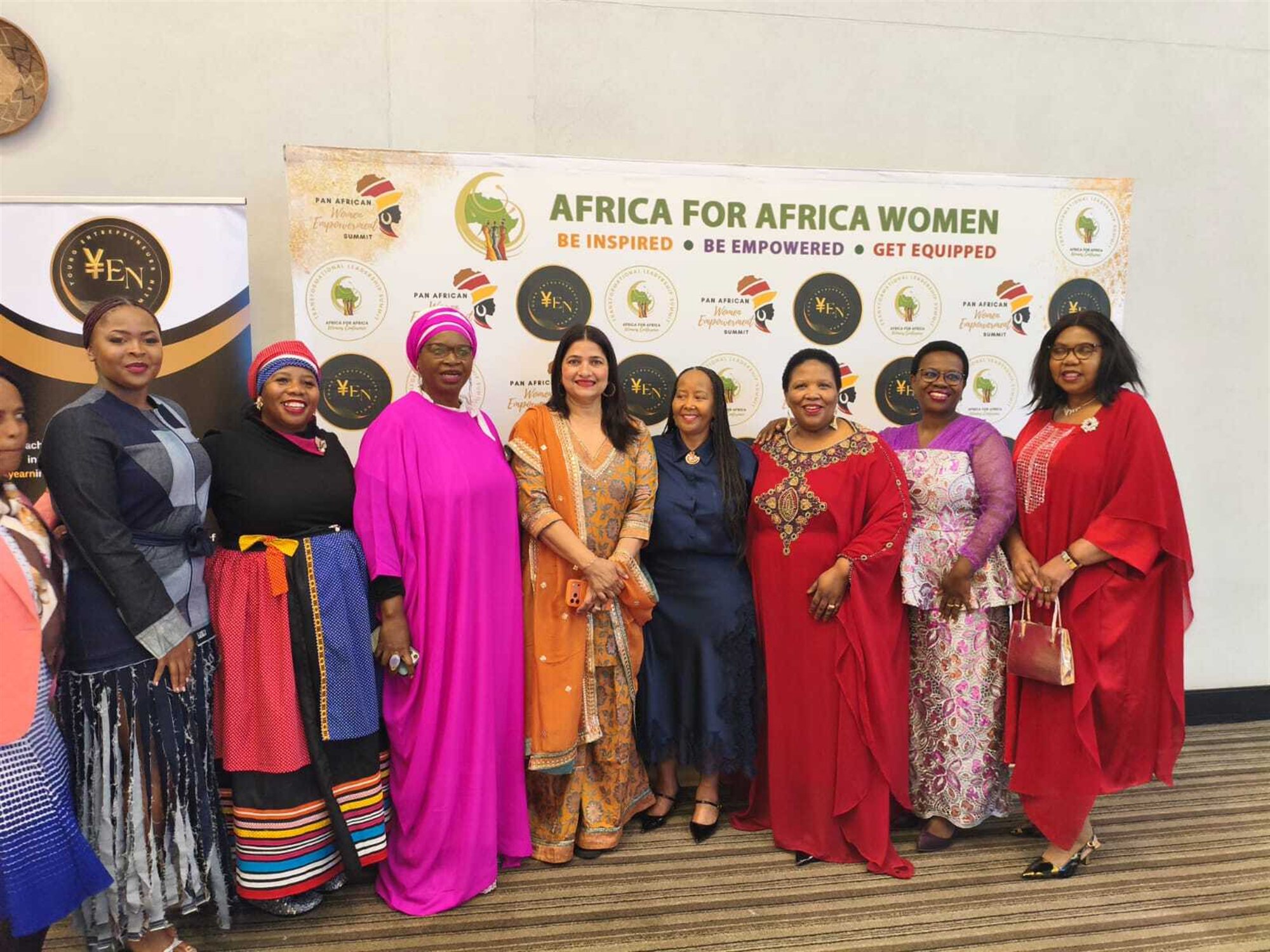 Delegates at the Pan African Women Empowerment Summit, standing together beneath an Africa for Africa Women banner