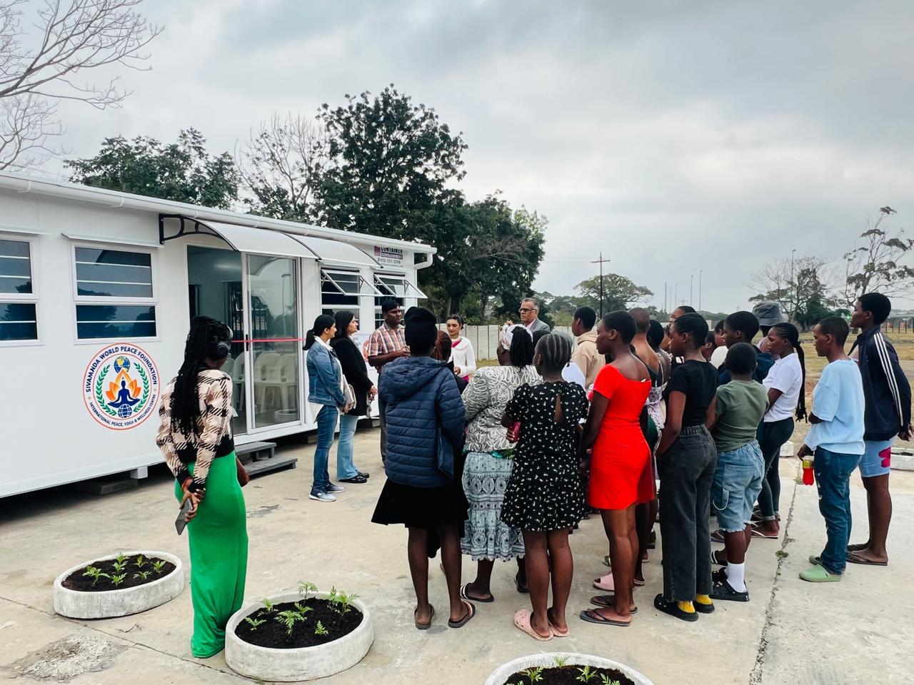 Community members gathered outside a mobile health and hygiene unit during a rural outreach visit